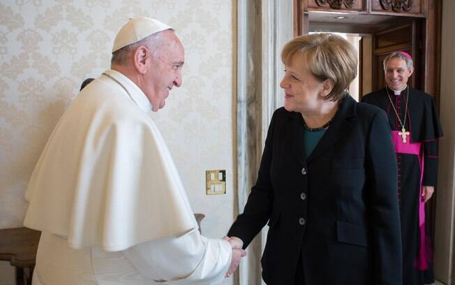 Papa Francisco aperta a mão da chanceler alemã Angela Merkel durante audiência privada no Vaticano
