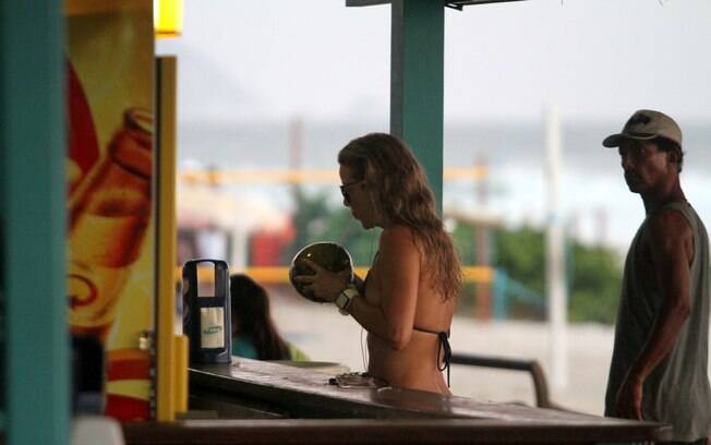 Christine Fernandes se refresca com água de coco após passeio na praia