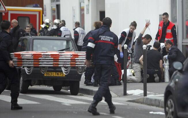 Uma pessoa ferida é tratado pela equipe de enfermagem fora do jornal satírico Charlie Hebdo em Paris (7/01)