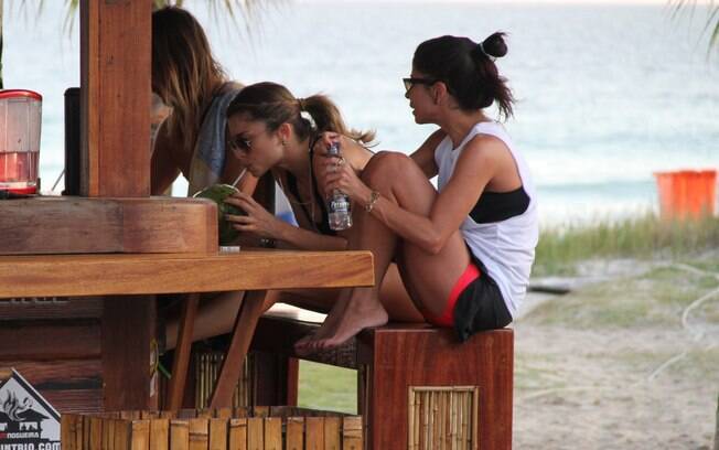 Antes de irem embora, Grazi Massafera e Ana Lima se refrescam com uma água de coco
