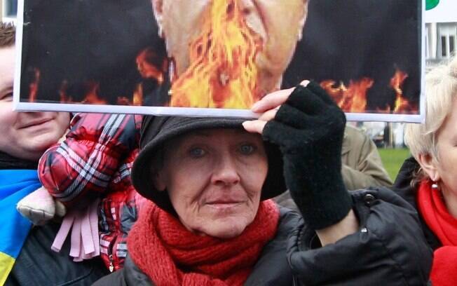 Ucraniana mostra retrato do presidente Viktor Yanukovych durante protestos em frente ao prédio do Parlamento Europeu em Brussels, Ucrânia (19/02)