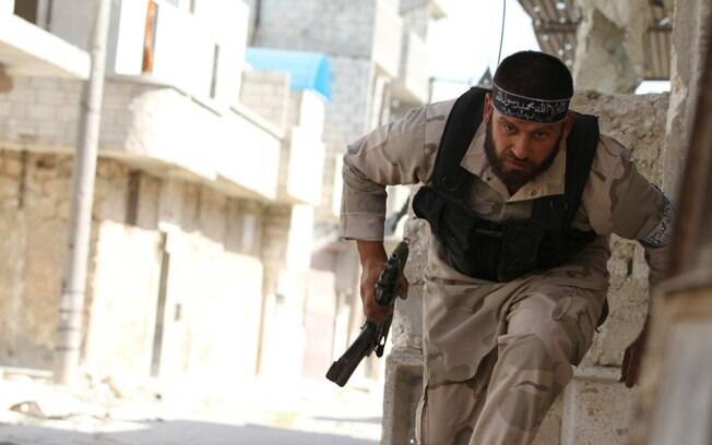 Combatente do Exército Livre da Síria corre para buscar proteção perto de aeroporto militar de Nairab, em Aleppo (12/06)