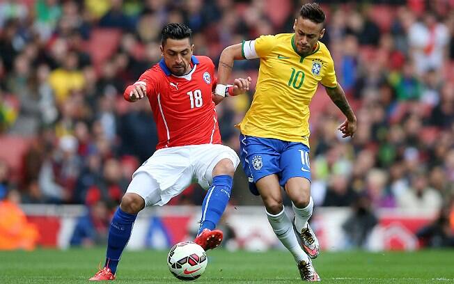 Neymar tenta se desvencilhar da marcação do chileno Gonzalo Jara durante amistoso. Foto: Getty Images/Paul Gilham