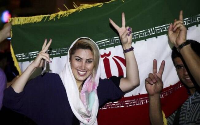 Iraniana faz sinal da vitória após confirmação de acordo nuclear, nesta terça-feira (14). Foto: AP