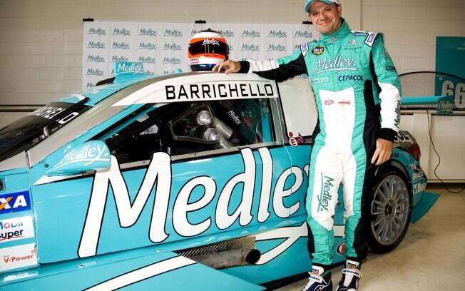 Rubens Barrichello posa ao lado de seu carro utilizado nas corridas