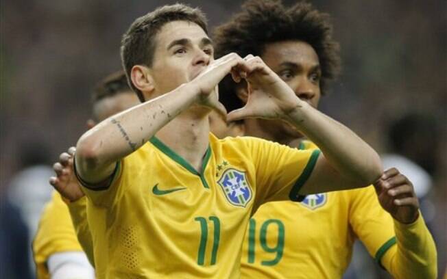 O meia Oscar corre para festejar o gol de empate do Brasil diante da França, seguido por William. Foto: AP Photo/Francois Mori