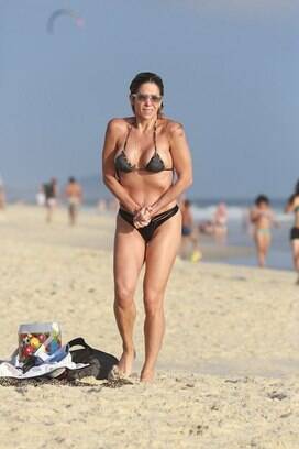 Famosa pela silhueta impecável, a atriz exibiu uma barriguinha fora do comum em dia de praia com os filhos. Foto: AgNews