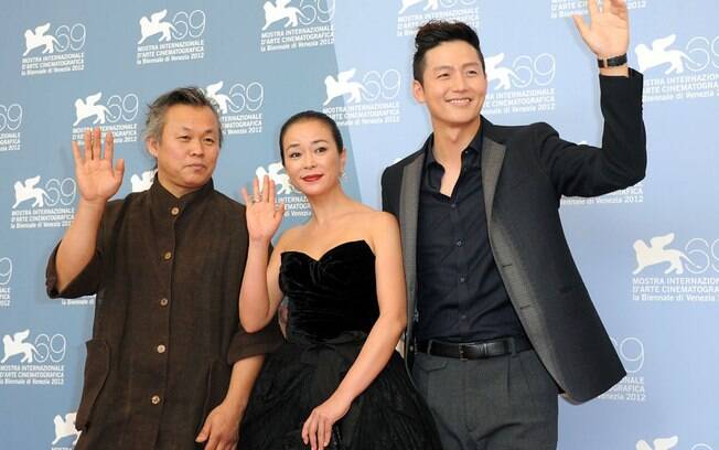 O diretor Kim Ki-duk, a atriz Cho Min-soo e o ator Lee Jung-jin acenam para fotógrafos no Festival de Veneza