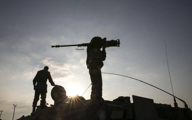 Soldado israelense detém arma sobre veículo blindado após cruzar fronteira de Gaza para Israel (28/07)