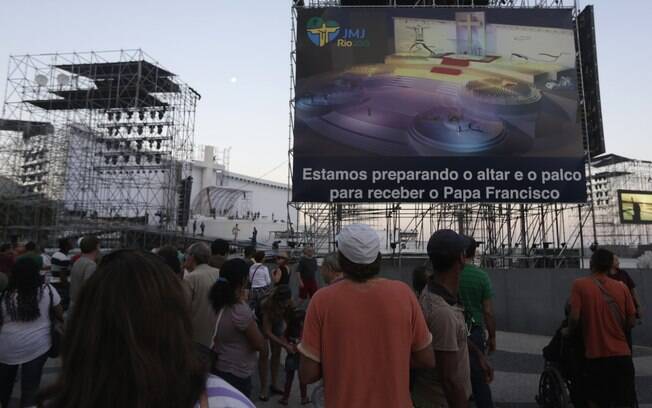 Público observa a montagem do palco que receberá o papa Francisco na praia de Copacabana, no Rio