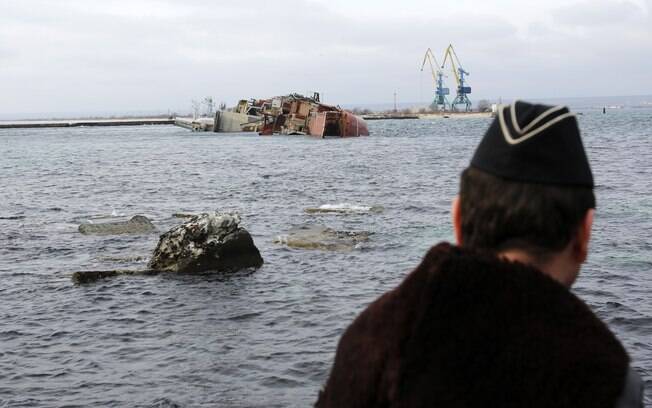 Marinheiro observa navio inativo Ochakov, que foi afundado por tropas russas e bloqueou o tráfego de cinco embarcações ucranianas em Myrnyi, oeste da Crimeia, Ucrânia (6/3)