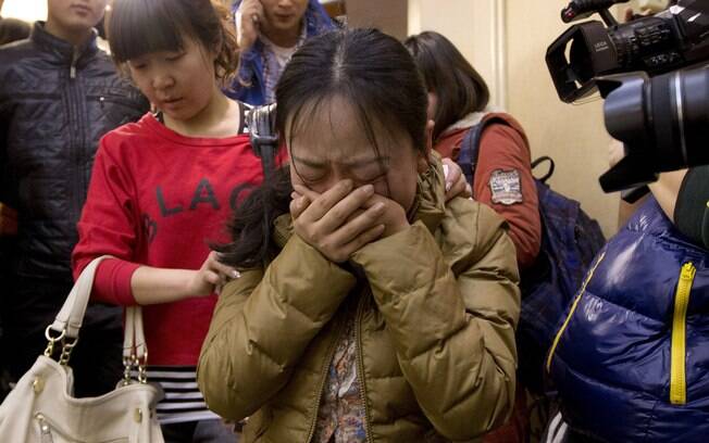 Parentes de passageiros do voo da Malaysia Airlines se desesperam à espera de informação das buscas (9/3). Foto: AP