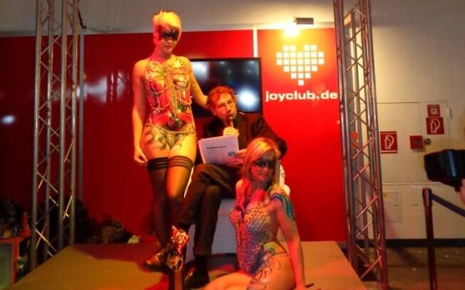 No estande da Joy Club, rede social erótica com mais de 1,5 milhão de perfis, escritor de contos eróticos apresenta sua obra em sessão de leitura acompanhado de modelos