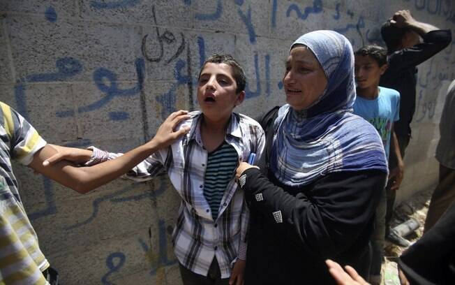 Parentes de menina de 4 anos morta em ataque israelense choram durante enterro em Rafah, sul da Faixa de Gaza (15/7)
