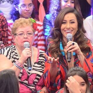 Sabrina senta com a plateia e demonstra interação total com o público
