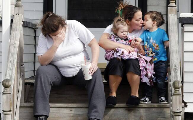 Vizinhos sentam do lado de fora de casa de pais de Krystle Campbell, que foi morta no ataque em Boston (16/04)