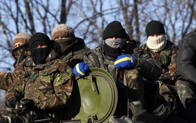 Soldados ucranianos sentam sobre veículo em estrada que se estende entre as cidades de Artemivsk, na Ucrânia, e Debaltseve