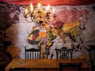 Um mapa gigante toma a parede da sala de jantar da família, nos Estados Unidos