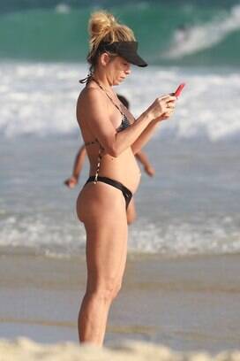 Famosa pela silhueta impecável, a atriz exibiu uma barriguinha fora do comum em dia de praia com os filhos. Foto: AgNews