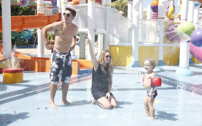 De vestido colado, Danielle Winits se diverte em atrações de parque aquático com o namorado e o filho