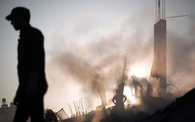 Palestinos fazem buscas em destroços de casa destruída por ataque aéreo de Israel em Gaza (8/7)
