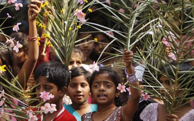 Crianças seguram folhas de palmeira durante procissão do Domingo de Ramos em Hyderabad, Índia