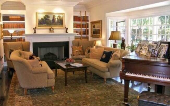 Na sala principal, o tapete com estampa floral se destaca sob o conjunto de sofá em linhas clássicas 
