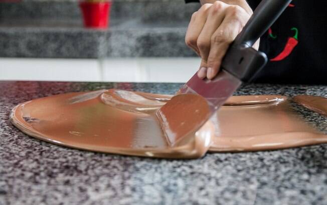 Faça movimentos rápidos e contínuos. O chocolate ao leite deve atingir 30°C. Teste colocando um pouco do ingrediente no lábio inferior. Tem que estar frio. Foto: Edu Cesar