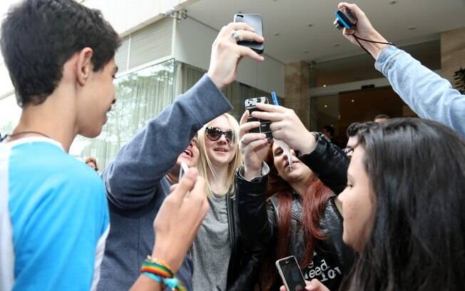 Dakota Fanning tira foto com fãs em porta de hotel, no Rio 