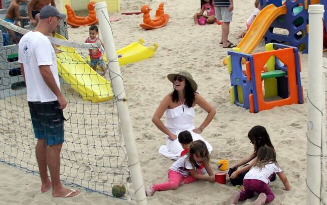 Amandha Lee e Nalbert levam os filhos Rafaela e Vitor para brincar na praia do Leblon
