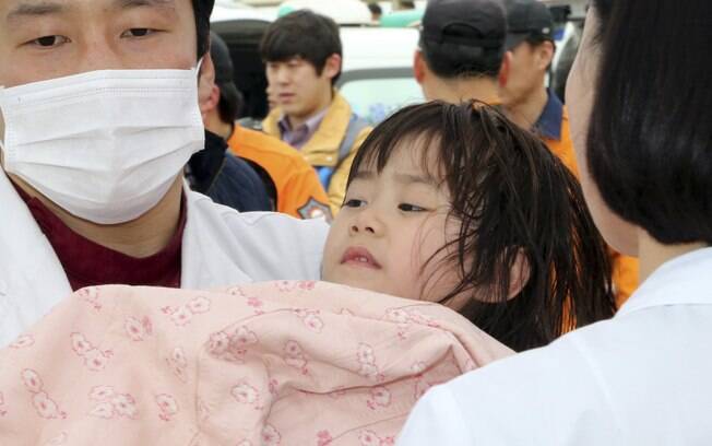 Criança é resgatada por policiais marítimos sul-coreanos ao sair do navio 'Sewol', que naufragou em Jindo, Coreia do Sul (16/04)