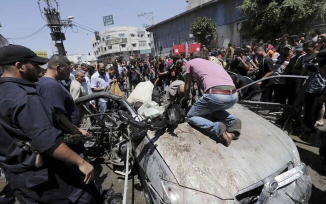 Palestinos fazem buscas em destroços de veículo depois de ataque aéreo de Israel em Gaza (8/7)