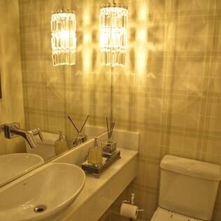 O lavabo ganha amplitude com o espelho e a estampa simétrica na parede. De Fabrício Forg