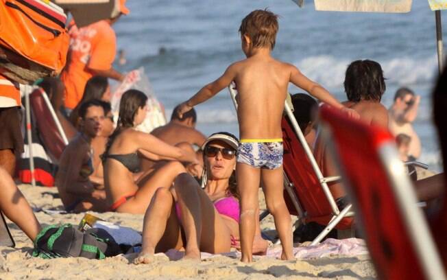Fernanda Lima foi à praia do Leblon, no Rio, com um dos gêmeos e amigos