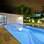 Para uma mansão no Guarujá (SP), o arquiteto Flávio Castro optou por uma piscina estreita e comprida, onde de um lado é possível ter a visão da sala fechada com vidro. Foto: Divulgação