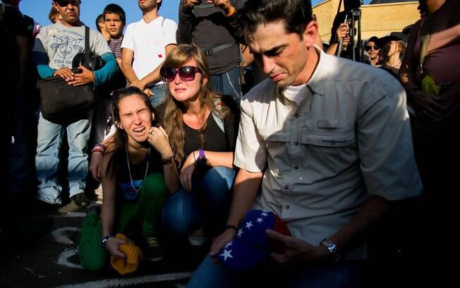 Estudantes choram durante vigília em Caracas por dois jovens mortos em confrontos violentos na Venezuela (13/2)