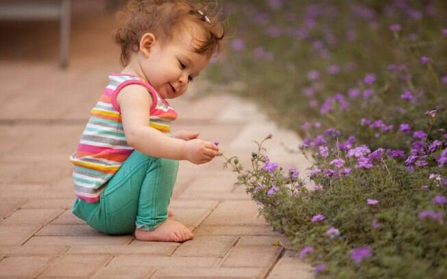 Estimule os pequenos a tocar flores, folhas e árvores quando estiverem em parques ou jardins. O contato com a natureza desenvolve o respeito por ela. Foto: Thinkstock