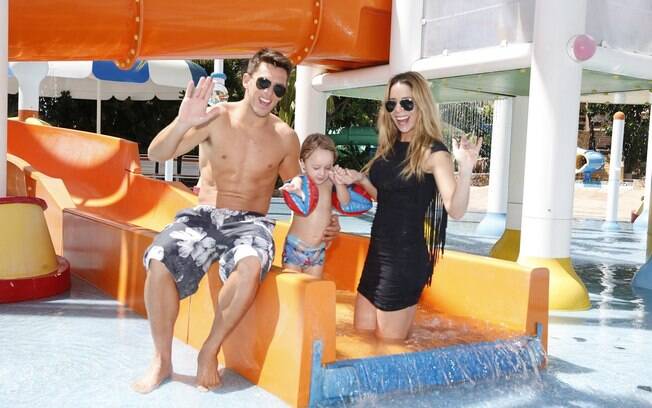 De vestido colado, Danielle Winits se diverte em atrações de parque aquático com o namorado e o filho