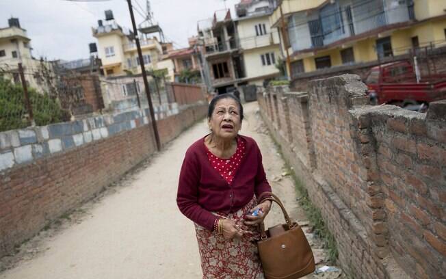 Idosa caminha por Katmandu, capital do Nepal e cidade mais atingida pelo terremoto que deixou dois mil mortos