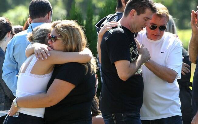 Gladimir Callegaro (2º à D), pai da vítima Marina Callegaro, e outros parentes choram durante seu enterro em cemitério na cidade de Santa Maria (28/1)