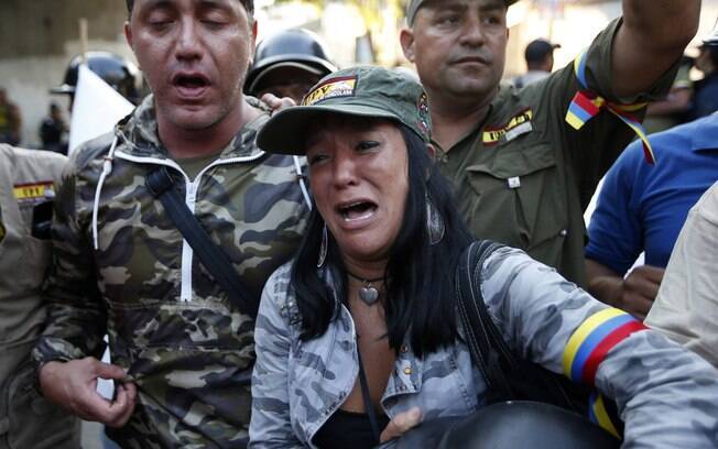 Venezuelanos choram após o anúncio da morte do presidente Hugo Chávez em Caracas (05/03)