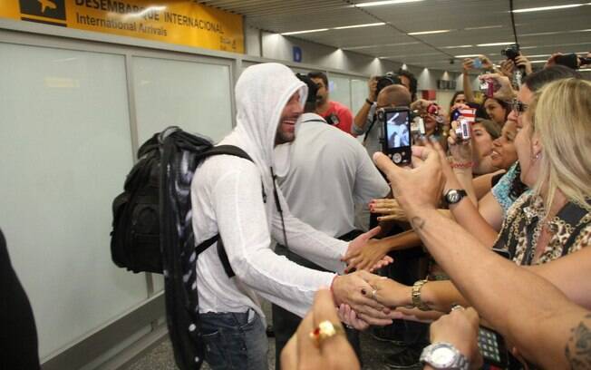 ... posar para as fotos dos fãs que o aguardavam no aeroporto internacional do Rio de Janeiro