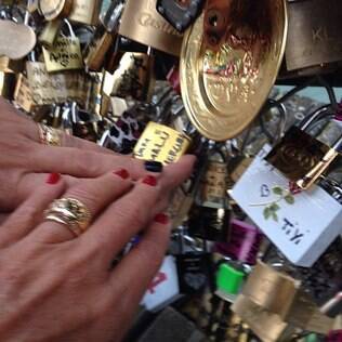 O casal coloca seu cadeado na Pont des Arts