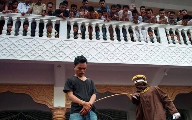Homem de Aceh é punido com chibatadas por homem mascarado. Seu crime: o jogo