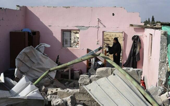 Palestina entre os restos de sua casa, que testemunhas disseram ter sido destruída durante a ofensiva israelense na vila Jöhr El-Deek, centro de Gaza (17/08)