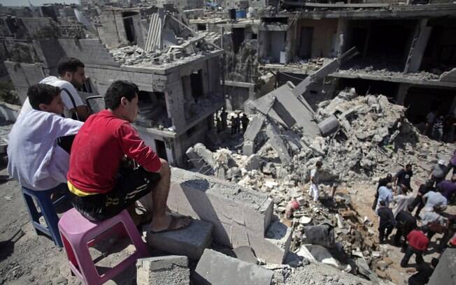 Palestinos fazem buscam em destroços de casa destruída onde oito membros da mesma família morreram em ataque de Israel (10/7)