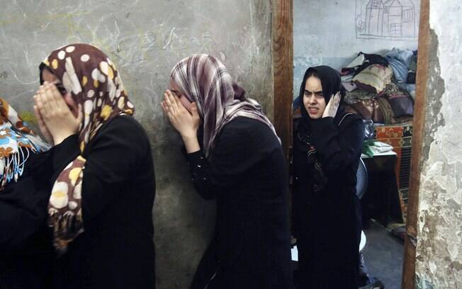 Parentes de oito membros de uma família palestina choram durante velório em Khan Younis, sul da Faixa de Gaza (10/7)