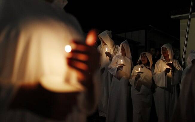 Fiéis vestidos com túnicas brancas seguram velas durante 'Procissão das Almas' em Mariana, Minas (30/03)