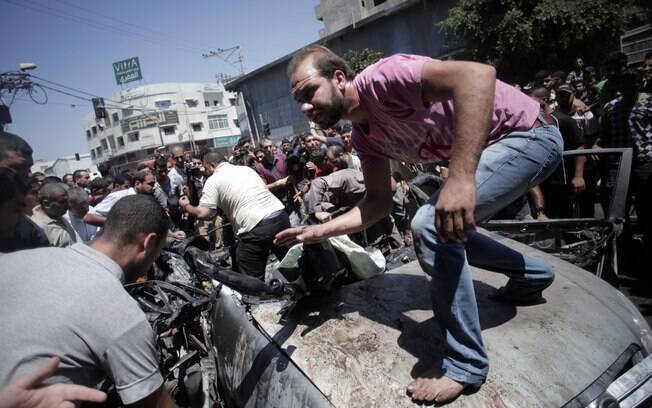 Palestinos fazem buscas em destroços de veículo depois de ataque aéreo de Israel em Gaza (8/7)