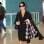 Com um vestido envelope preto, sapatos clássicos e um sobretudo para garantir calor sob o ar condicionado do avião, Luiza Brunet novamente arrasa no look casaual. Foto: Getty Images